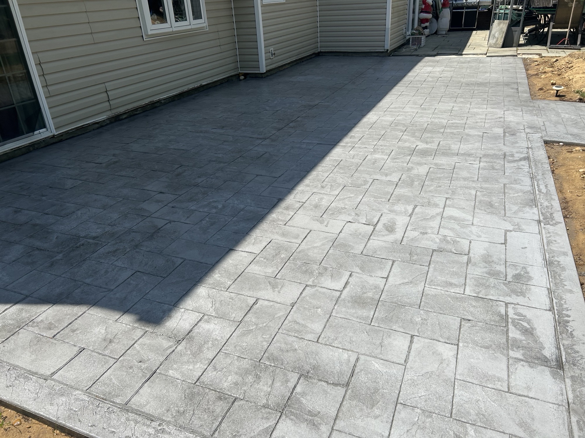 Large stamped concrete backyard patio with border
